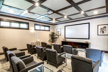 Private theater room with projection screen and lounge seating